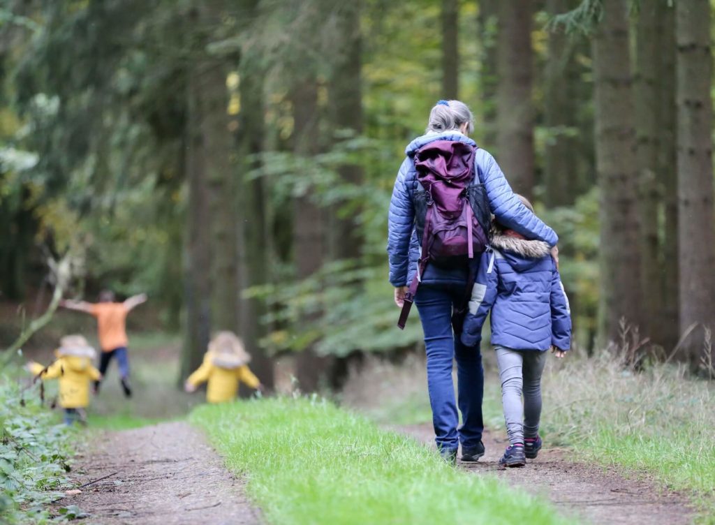 Madre e hija caminando por el bosque con unas chaquetas para el frio